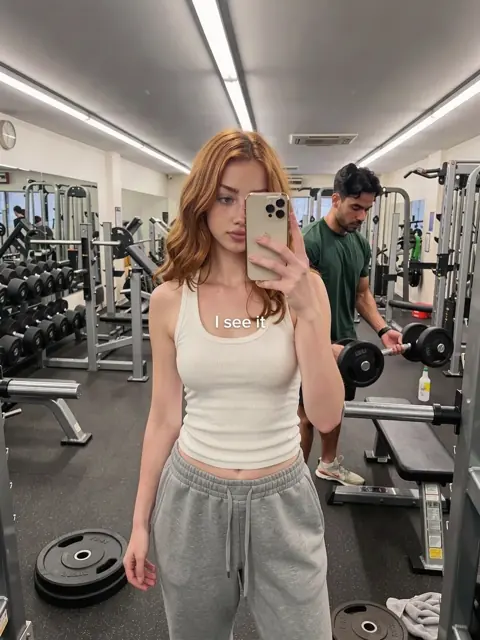 Remake slide 1: a red-haired creator's gym mirror selfie, a guy at the weights behind her, text I see it